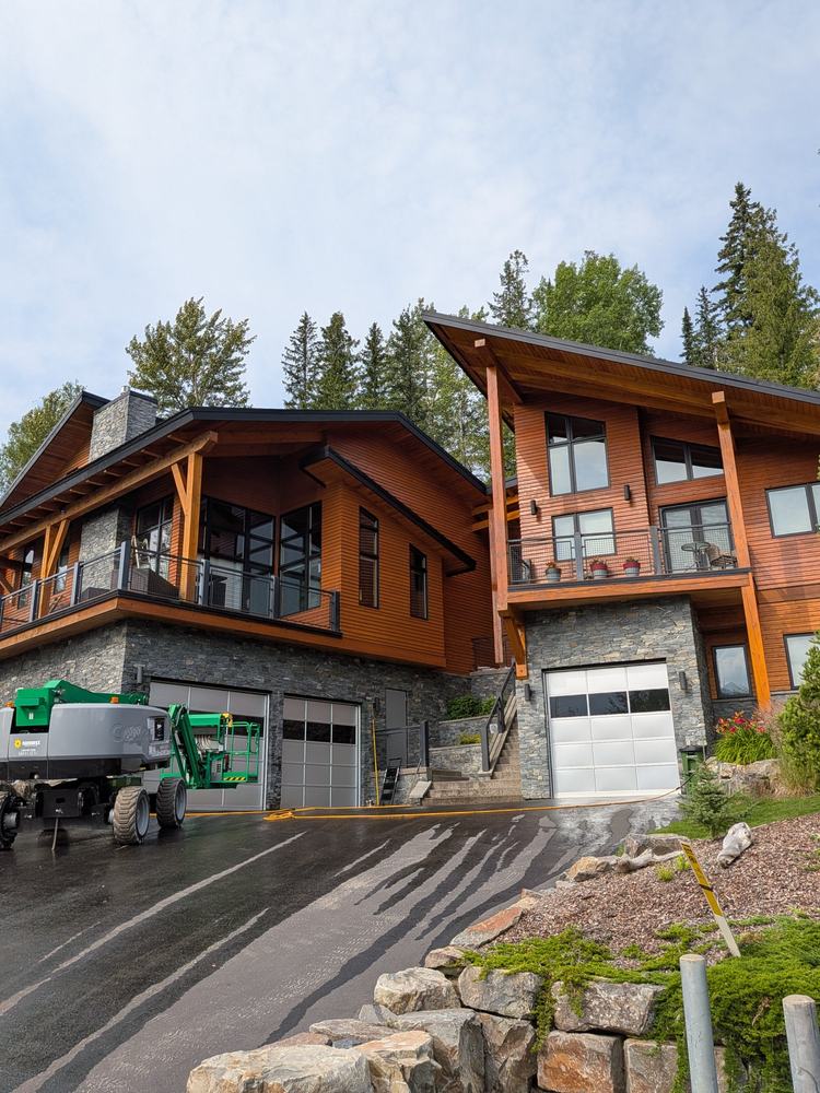 Boom lift in the driveway of two modern homes during an exterior repaint