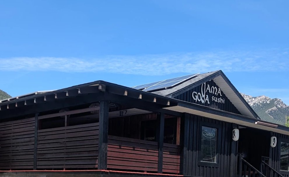 Yama Goya Sushi restaurant in Fernie after its exterior repaint, dark siding with red accents and mountains behind